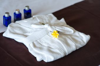 close-up shot of bathroom amenities with bathrobe on bed in hotel room